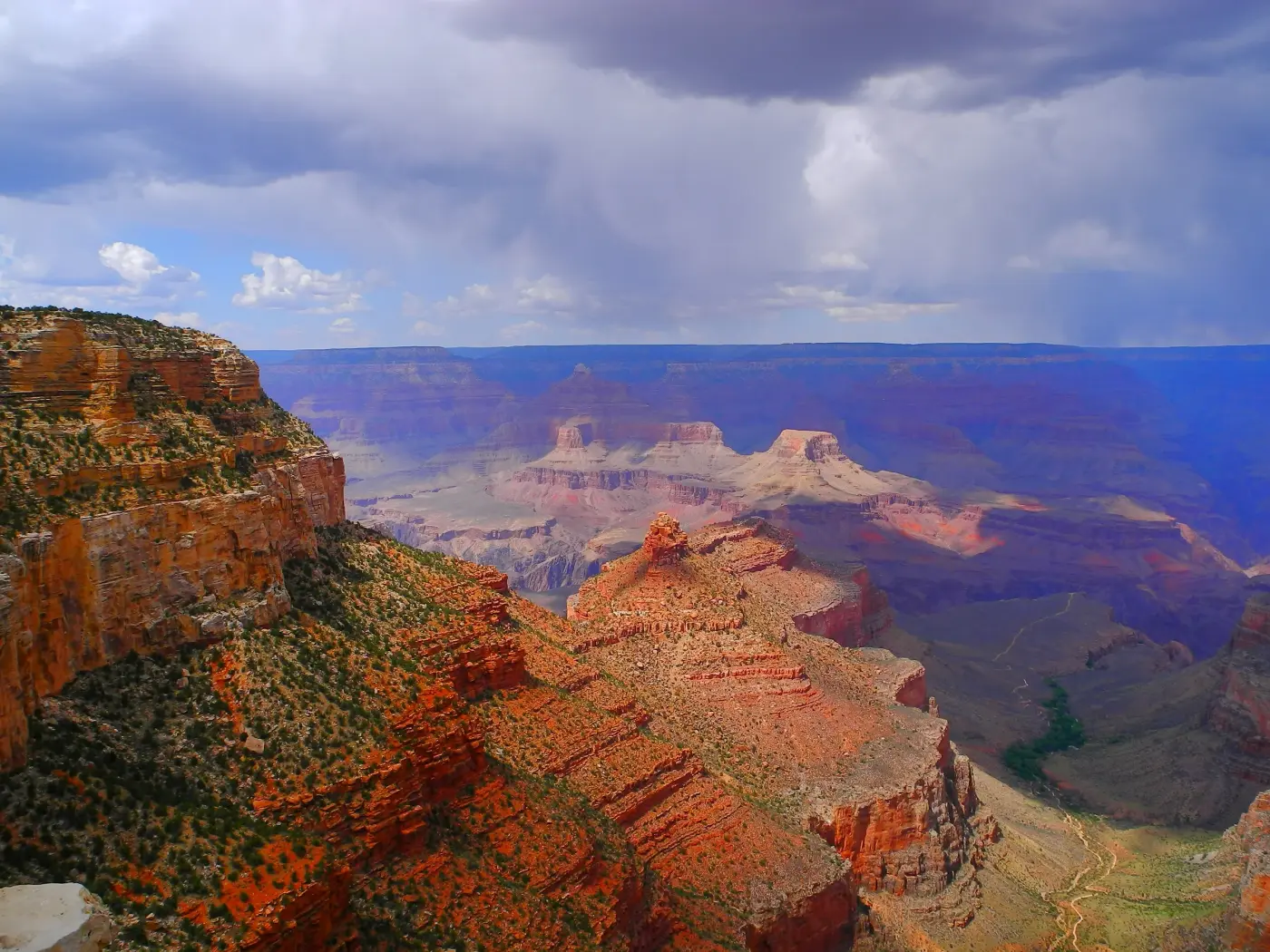 Grand Canyon South Rim under a dramatic stormy sky with canyon layers stretching to the horizon